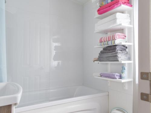 a bathroom with a shower and a toilet and towels at Birch Grove in Saint Osyth