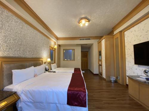 a hotel room with a bed and a flat screen tv at I Live Motel in Kaohsiung