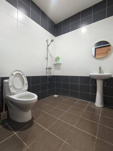 a bathroom with a toilet and a sink at Sakura homestay 5 bedrooms - Spring Lopeng 14 pax in Miri