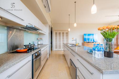 a large kitchen with white cabinets and granite counter tops at Park view Avalon Apartment District 1 HCM City in Ho Chi Minh City