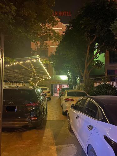 a row of parked cars on a street at night at Truong An NoiBai Airport Hotel in Noi Bai