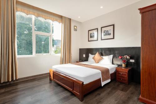 Truong An NoiBai Airport Hotel في Noi Bai: غرفه فندقيه بسرير ونافذه
