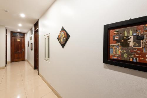 a hallway with a painting and a clock on a wall at Truong An NoiBai Airport Hotel in Noi Bai