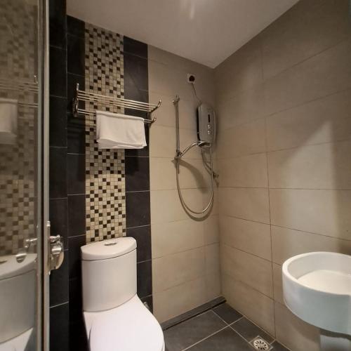 a bathroom with a toilet and a sink at C Hotel in Jitra