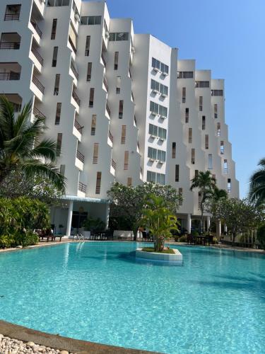 a swimming pool in front of a building at sea sand sun resort Executive 607 Mae Rumphueng beach in Rayong