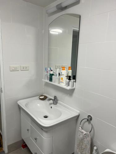a white bathroom with a sink and a mirror at sea sand sun resort Executive 607 Mae Rumphueng beach in Rayong