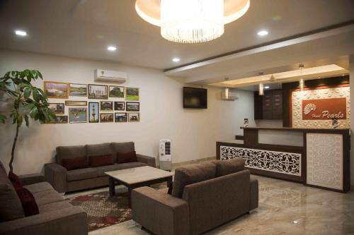Sala de estar con 2 sofás y mesa en Hotel Pearls, en Aurangabad