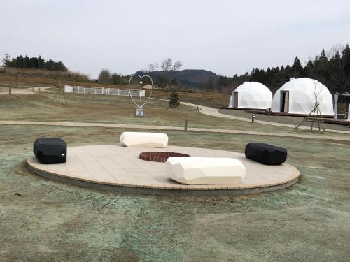 two white chairs and two white tents in a field at chillout glamping zao in Zao
