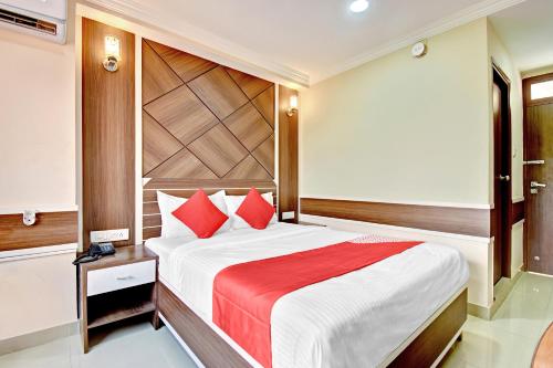 - une chambre avec un grand lit et des oreillers rouges dans l'établissement OYO Hotel Star Ldh, à Ludhiana