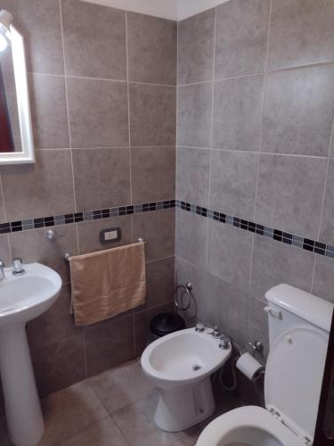 a bathroom with a toilet and a sink at Departamento amoblado Rio Cuarto in Río Cuarto