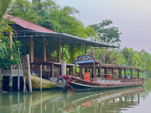 a boat parked next to a building on the water at Boutique Lodge Can Tho Homestay in Can Tho