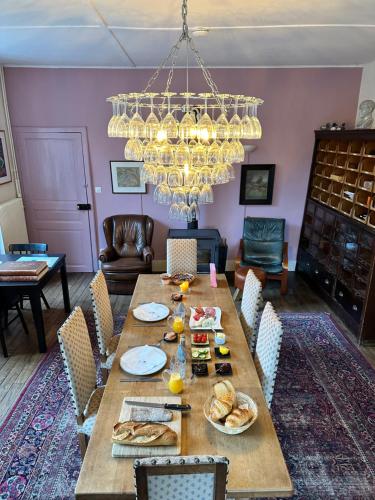 a dining room with a table with food and a chandelier at Villa Vallière bed&breakfast in Vallières