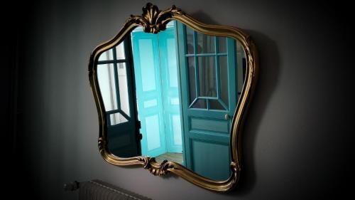 a mirror on a wall with a blue door at Villa Vallière bed&breakfast in Vallières