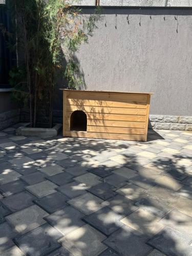 a wooden dog house sitting on a patio at GREEN THERAPY Self Check In in Yerevan