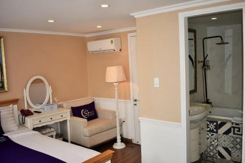 1 dormitorio con cama, lavabo y espejo en Saigon By Night Boutique Hotel, en Ho Chi Minh