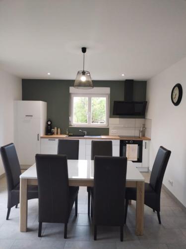 - une cuisine avec une table à manger et des chaises dans l'établissement Maison tout confort, à La Voivre