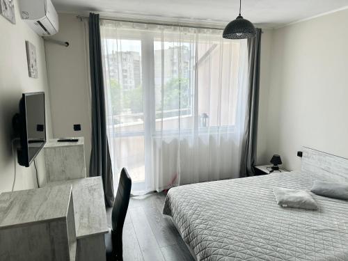 a bedroom with a bed and a large window at Budget Luxury Apartment - Absolutely New Building! in Ruse