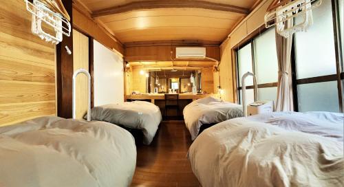 a group of three beds in a room at 奄美ゲストハウス HUB a nice INN in Setouchi