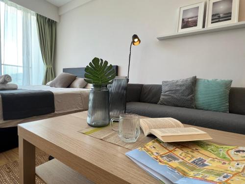 a living room with a couch and a table at AruSuites Tanjung Aru Kota Kinabalu By LAXZONE in Kota Kinabalu