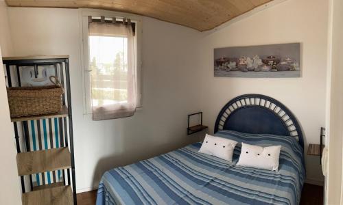 um quarto com uma cama com almofadas e uma janela em Marina 2 , appartement vue mer exceptionnelle em Saint-Cyprien