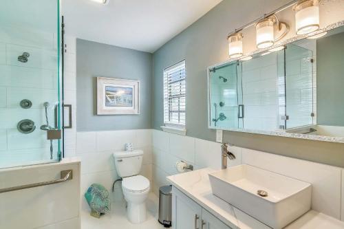 a bathroom with a toilet and a sink and a mirror at Herons Nest by VTrips in Galveston