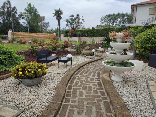 a garden with a pathway with a fountain and flowers at Euro Hotel in Tirrenia