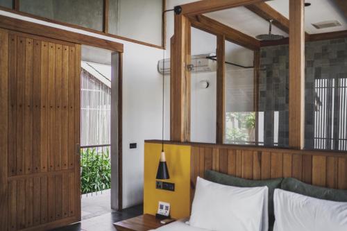 a bedroom with a bed with a wooden headboard at The Saren in Tanah Lot