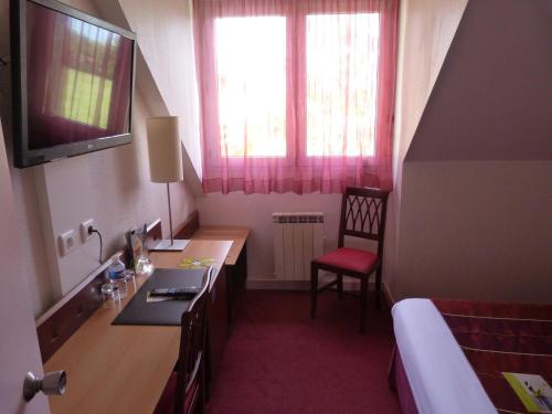 a room with a desk and a bedroom with a bed at Logis De La Loire - Restaurant Les Bateliers in Ancenis