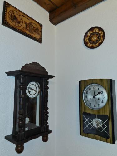 two clocks are hanging on a wall at Apartments "Old house Mustafic" in Bar