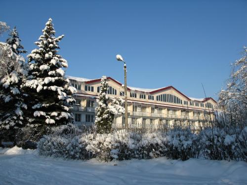ein großes Gebäude im Schnee mit einem Weihnachtsbaum in der Unterkunft Motel Poltava in Poltawa