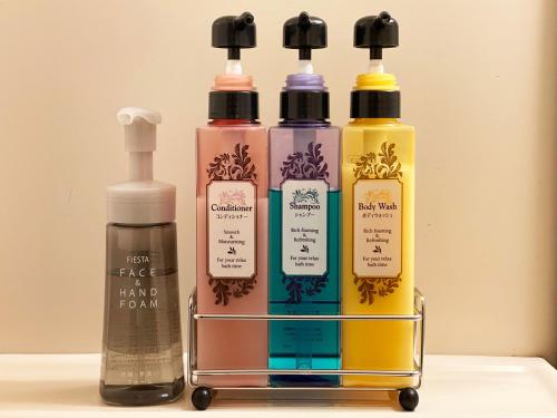 three bottles of different colored liquids in a rack at Hotel Pearl City Tendo in Tendo