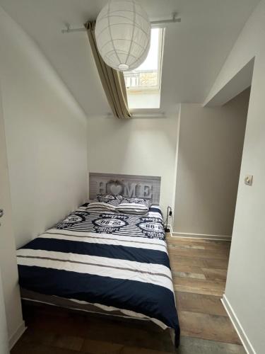 een slaapkamer met een bed en een raam bij Grand studio, chambre séparée, calme, centre ville prox Cathédrale - parking possible in Orléans