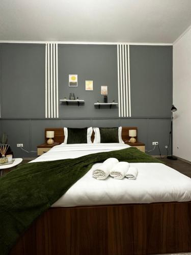 a bedroom with a large bed with two towels on it at Borkum in Sibiu