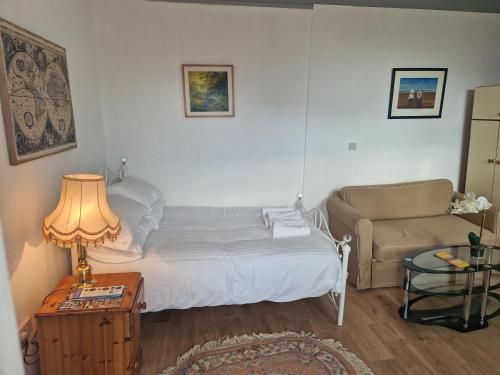 Un dormitorio pequeño con una cama y un sofá. en Harbour Street Rooms, en Kent