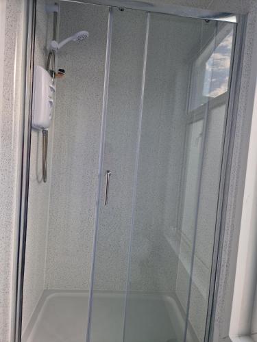 a shower with a glass door in a bathroom at Harbour Street Rooms in Kent