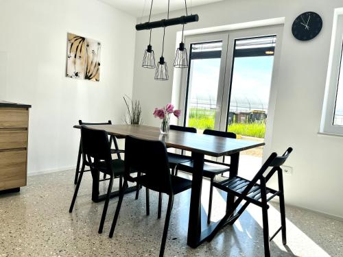 a dining room table with chairs and a clock on the wall at Chic&cozy with Sauna in Ljubljana