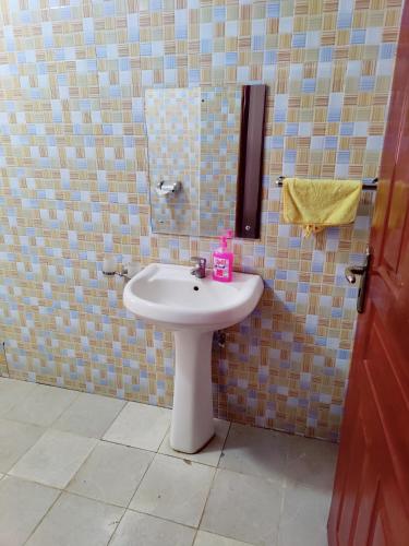 uma casa de banho com um lavatório branco e um espelho. em Modern 1-bdrm Apartment 15min to CBD. 20min to UN em Nairobi