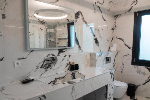 a white bathroom with a sink and a mirror at Avaton Luxury Resort and Spa Access the Enigma - Adults Only & Kids 14 Plus- in Asprovalta