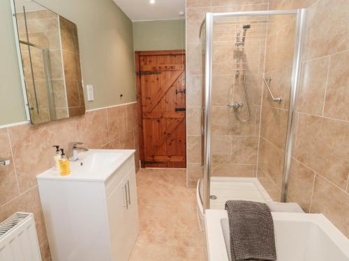 uma casa de banho com um chuveiro e um lavatório. em Forge Cottage em Morpeth