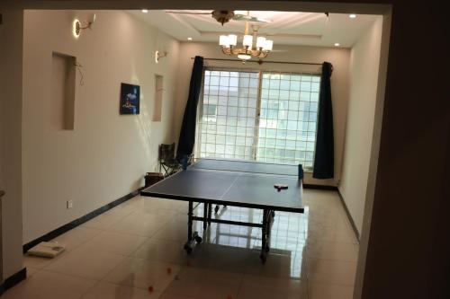 a ping pong table in a room with a window at N N Guests Palace in Islamabad