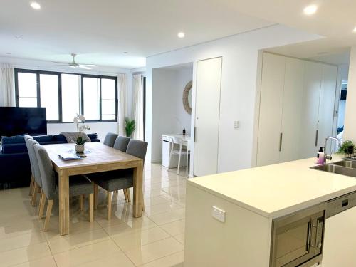 a kitchen and a living room with a table in a room at Absolute Waterfront - Tropical Oasis Over The Water in Darwin