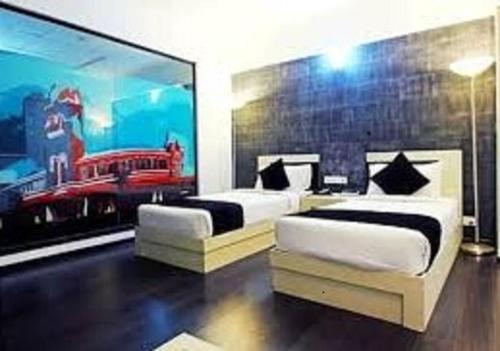 a bedroom with two beds and a large painting at Hotel Olive Eva in Kakkanad