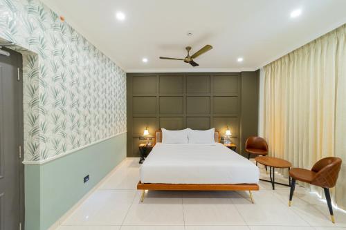 a hotel room with a bed and a chair at De Fleur Hotel in Puducherry