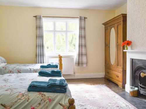 1 dormitorio con 1 cama, chimenea y ventana en Upper Broughton Farm Cottage, en Snead