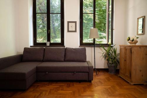 a couch sitting in a living room with windows at Spacious apartment in strategic location - Green in Trento