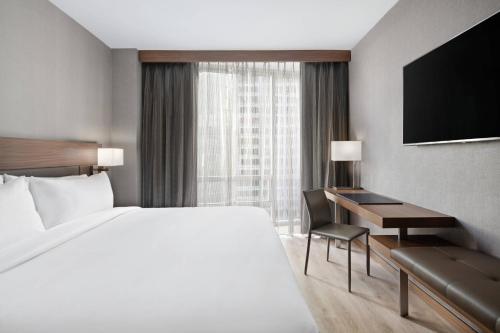 um quarto de hotel com uma cama grande e uma secretária em AC Hotel by Marriott New York Downtown em Nova York