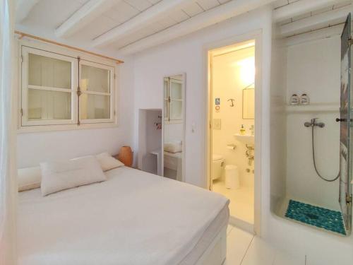 a white bedroom with a bed and a shower at The Sunday House in the heart of Mykonos Town in Mýkonos City