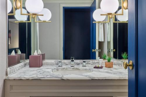 a bathroom with a sink and a large mirror at The Camby, Autograph Collection in Phoenix