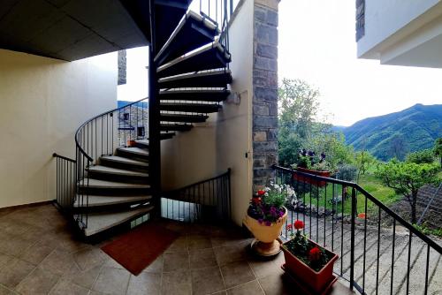 una escalera de caracol en una casa con montañas en el fondo en Apartamentos Ordesa Infinita, en Asín de Broto