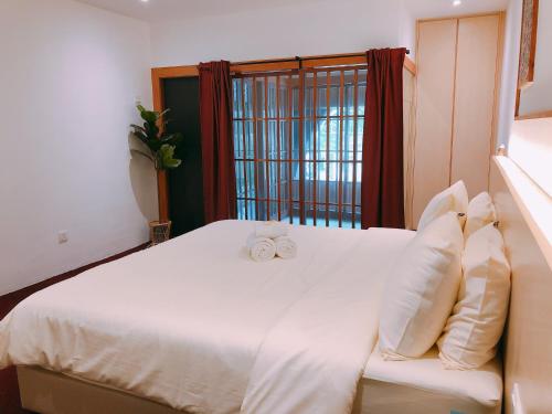 Un dormitorio con una cama blanca con dos arcos blancos. en Domo Japanese Style Bedroom en Melaka